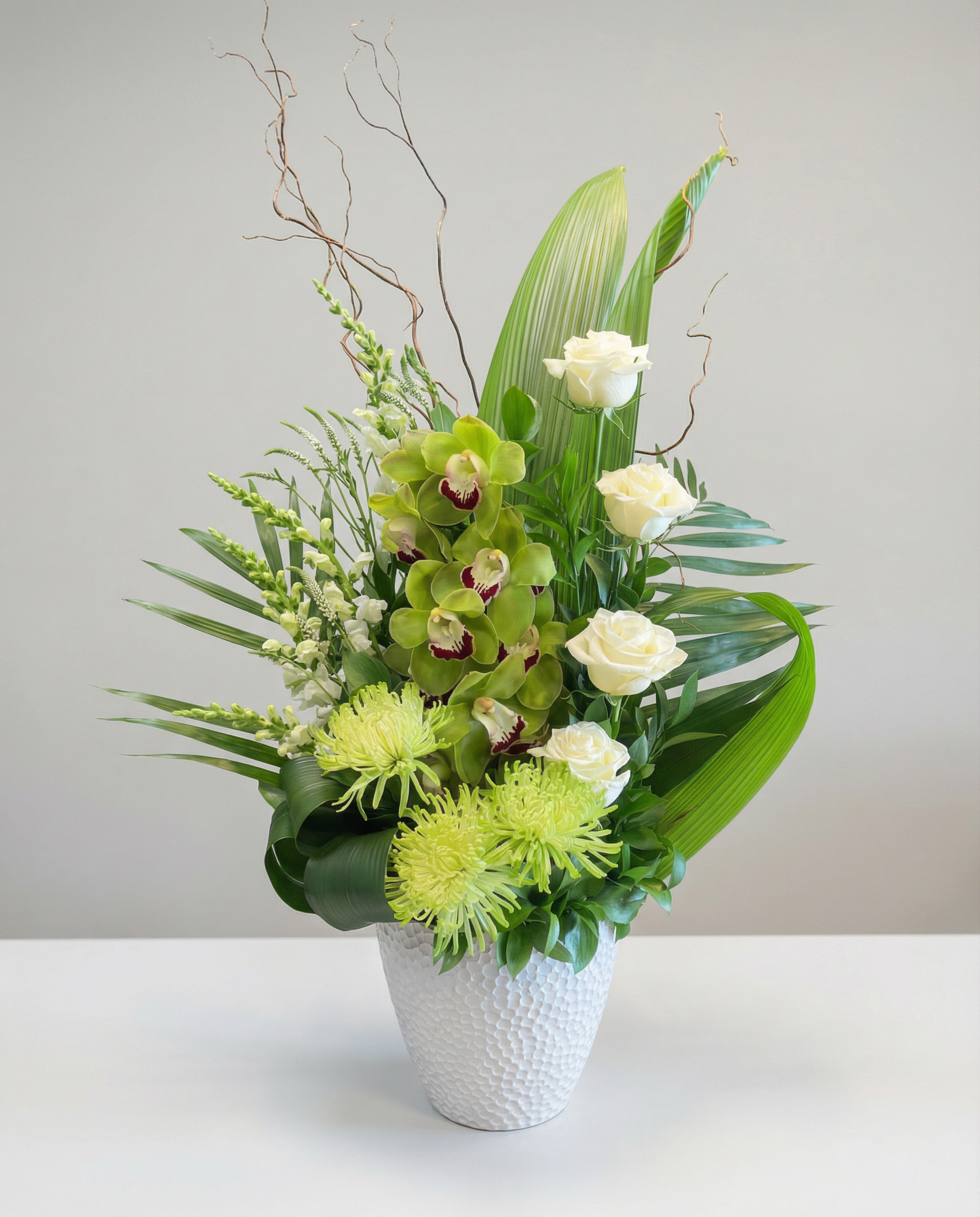 Corbeille funéraire élégante mettant en valeur le cymbidium vert, la rose blanche et un assortiment de fleurs vertes. Une composition naturelle et équilibrée, évoquant paix, espoir et douceur, parfaite pour un hommage tout en sobriété.